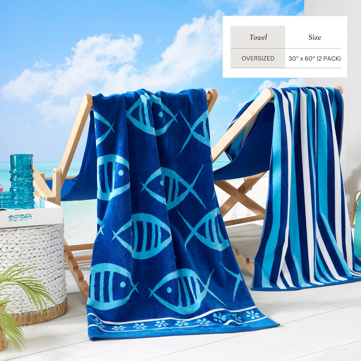 Blue fish-print cotton velour beach towel with striped section, draped on chair