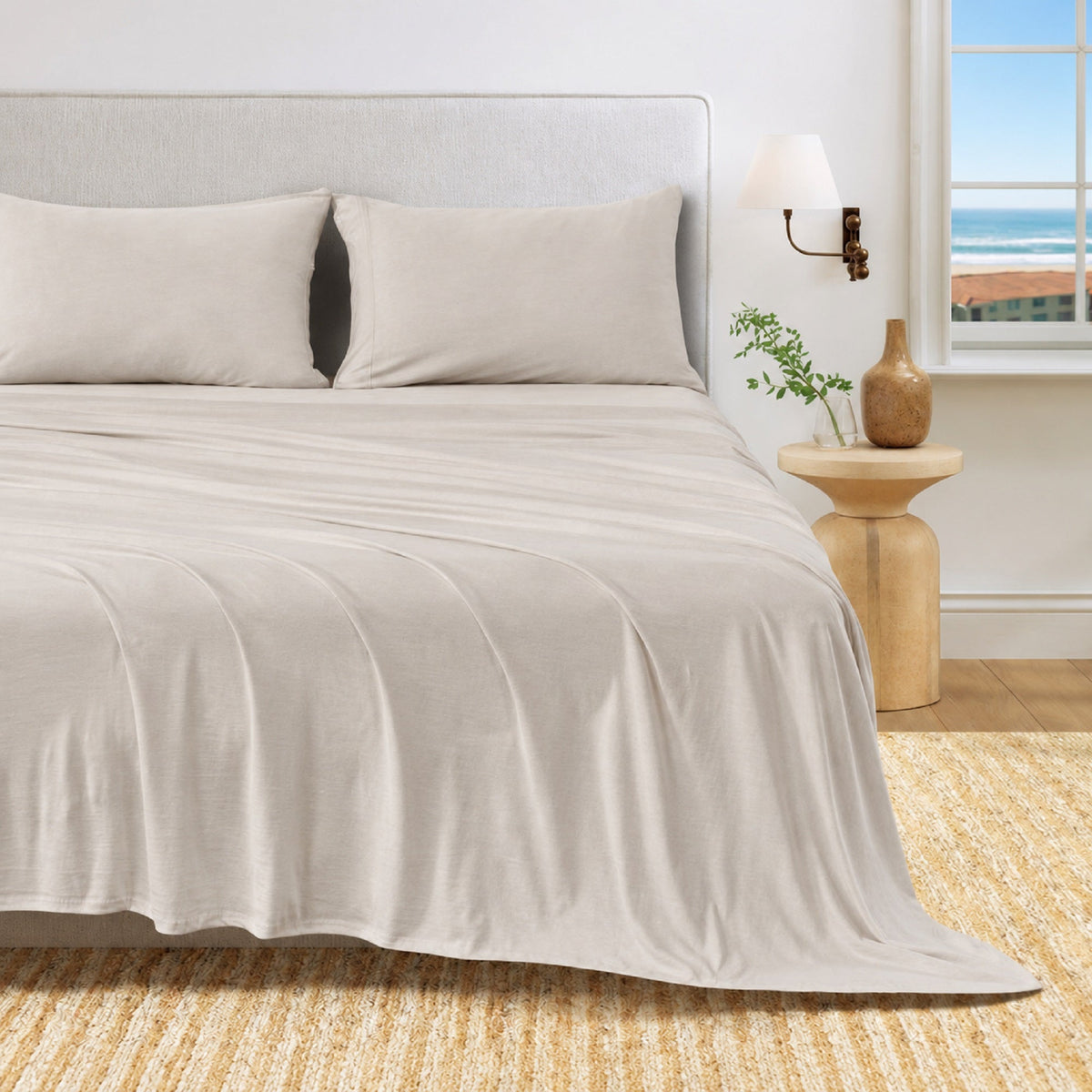 Sand jersey knit sheet set on bed with two pillowcases