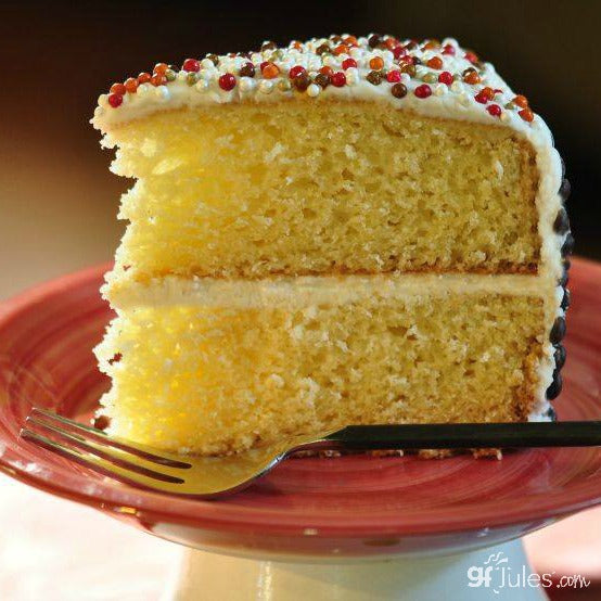 Gluten-free flour cake slice with white frosting and sprinkle topping.