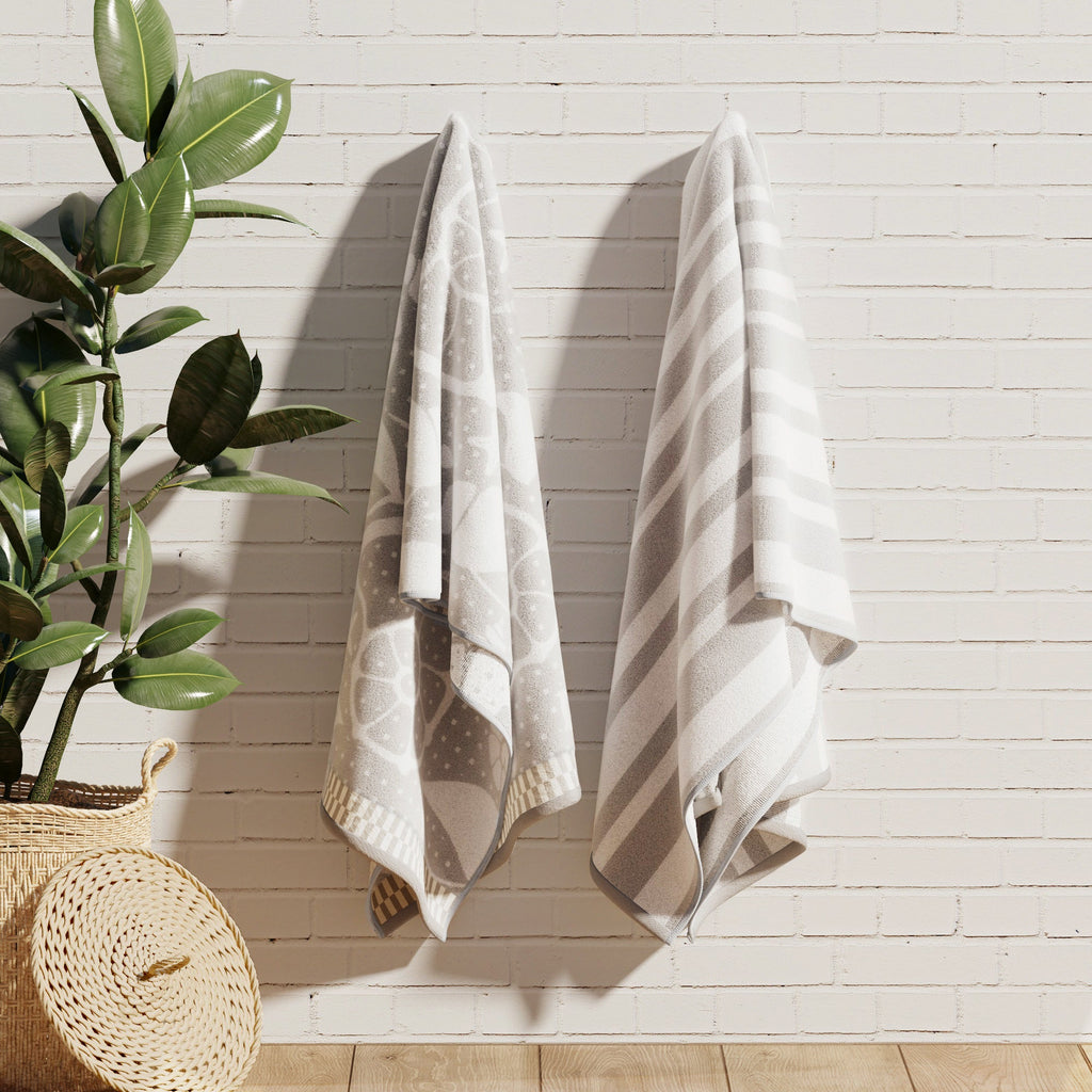 Gray and white cotton velour towels hanging, with nature and striped designs