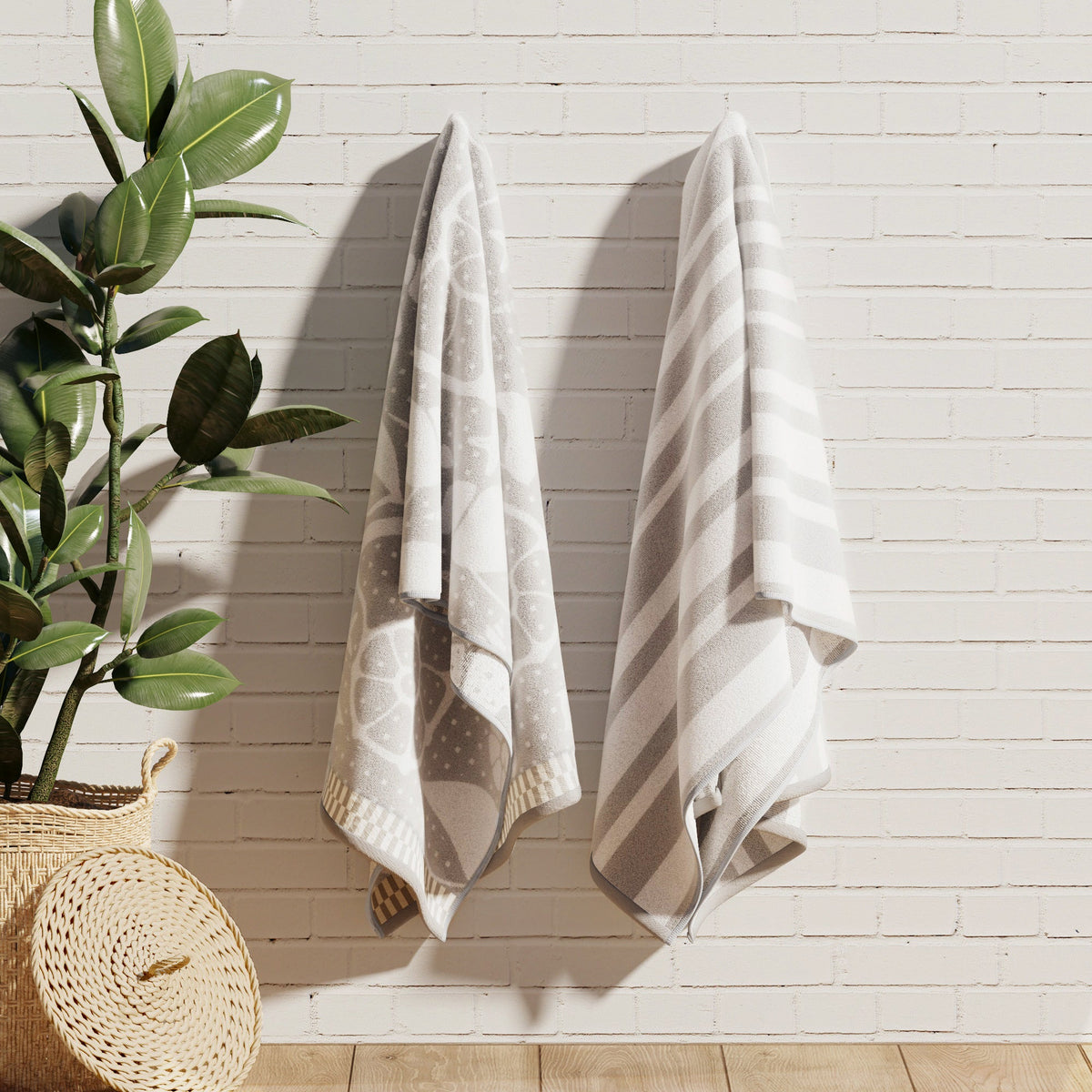 Gray and white cotton velour towels hanging, with nature and striped designs