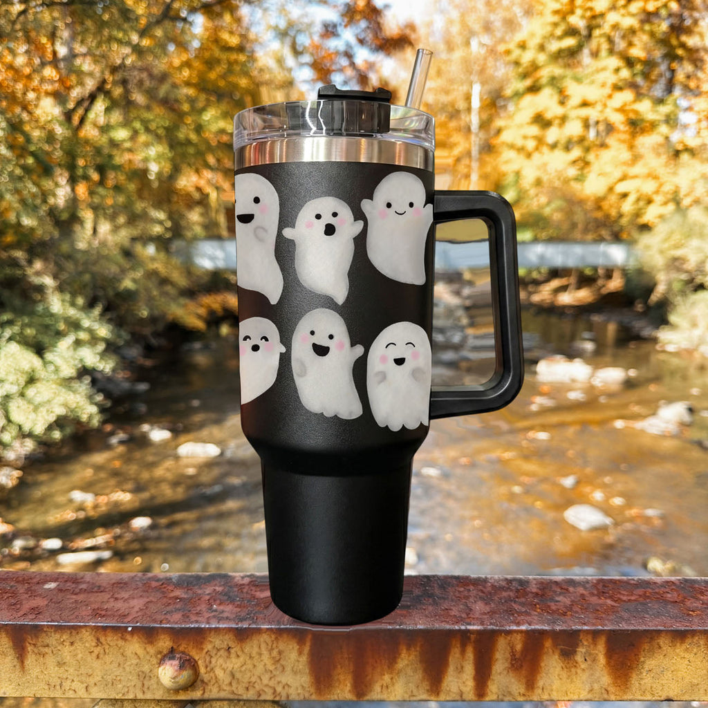 Black 40oz ghost tumbler with clear lid, straw, and side handle on tabletop