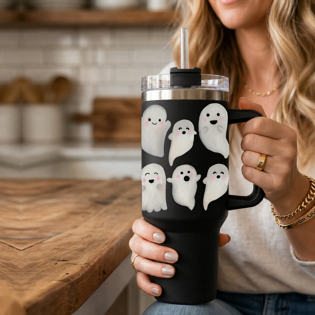 40oz black ghost tumbler close-up with clear lid and metal straw in hand.