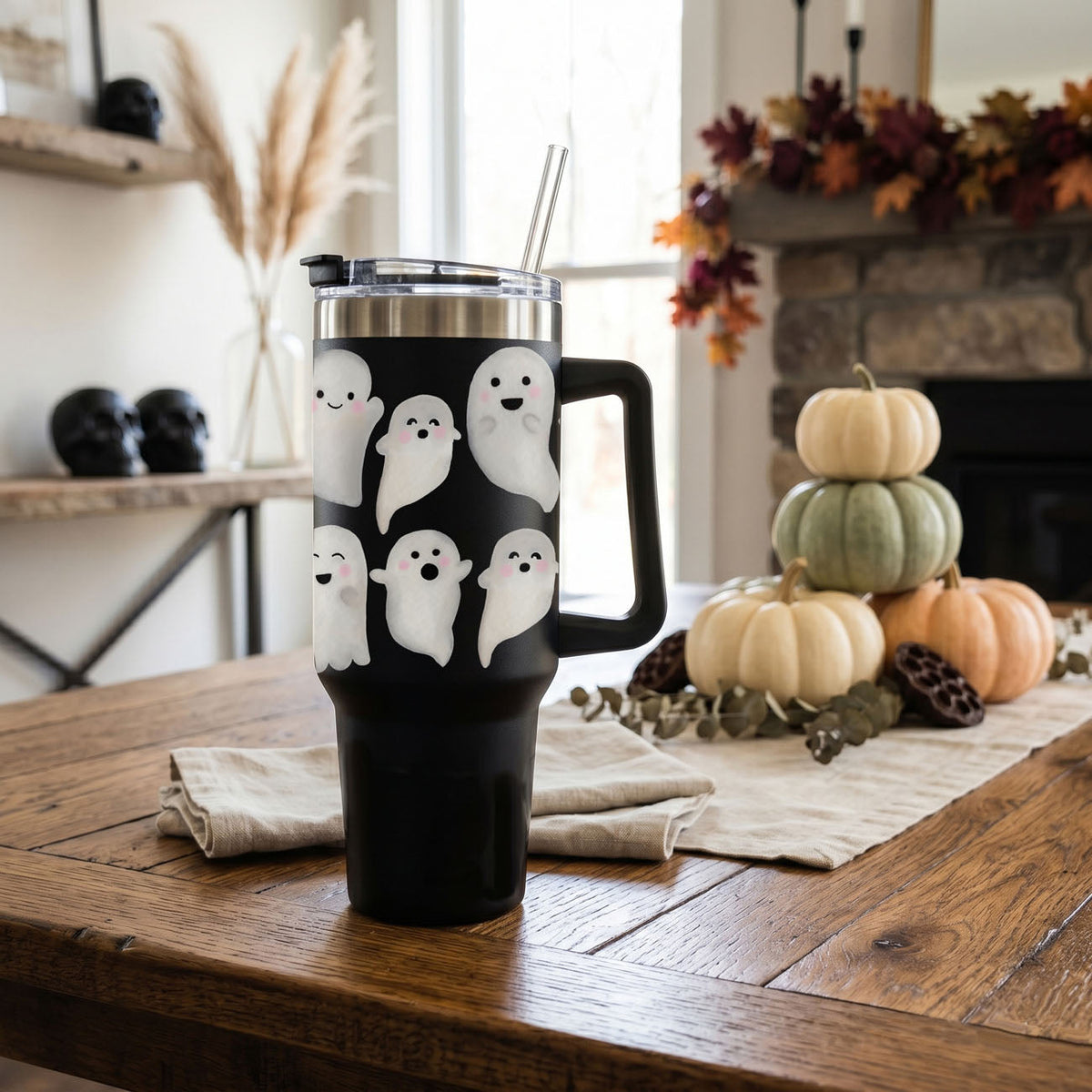 40oz black tumbler with ghost pattern, clear lid, and metal straw on table.