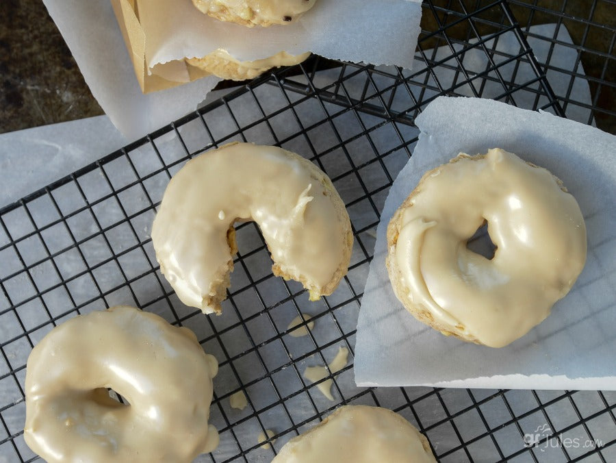 Gluten-free flour doughnuts cooling on a wire rack with light glaze.