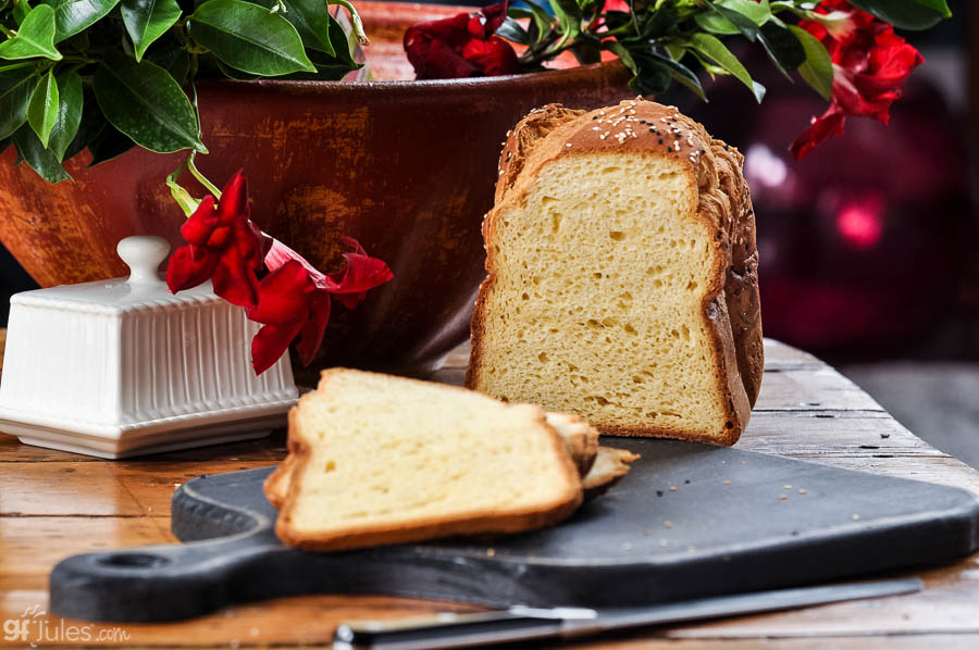 Gluten-free flour bread loaf with sliced pieces on a wooden serving board.