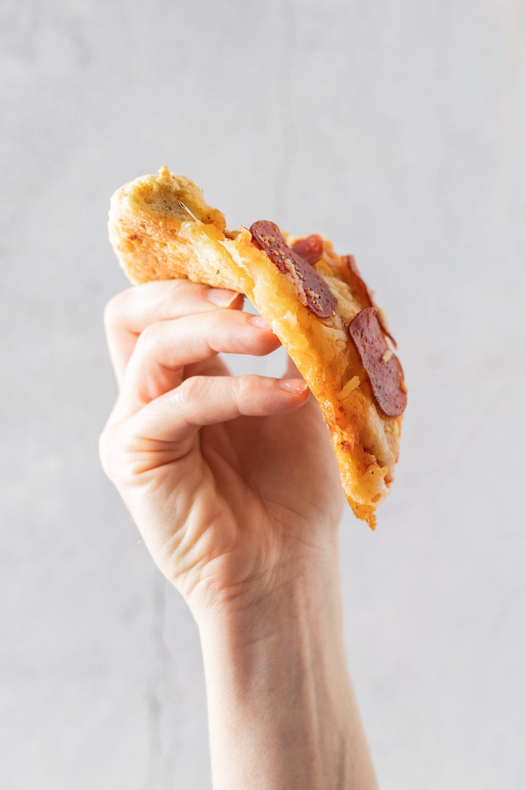 Gluten-free pizza crust slice with cheese and pepperoni toppings