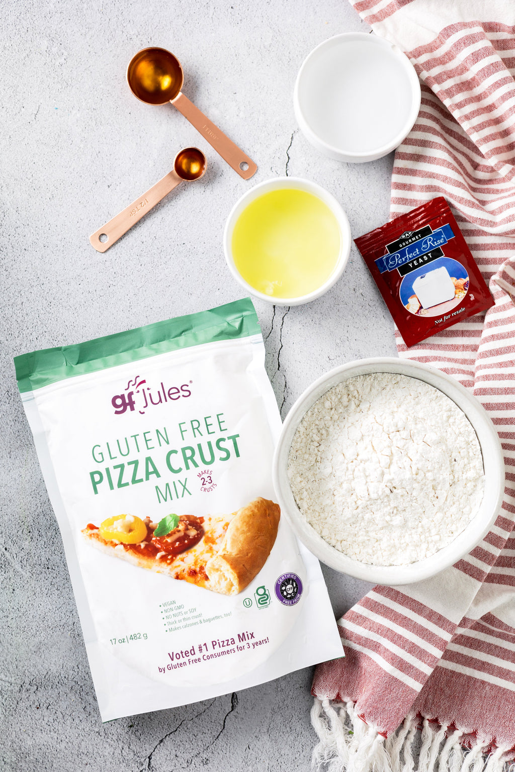 gfJules gluten-free pizza crust mix pouch with bowls of ingredients for baking