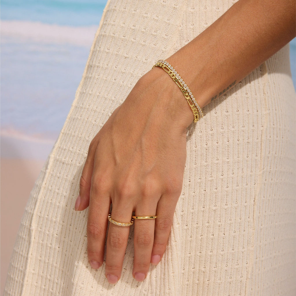 Gold-tone eternity band ring with rectangular clear stones on hand