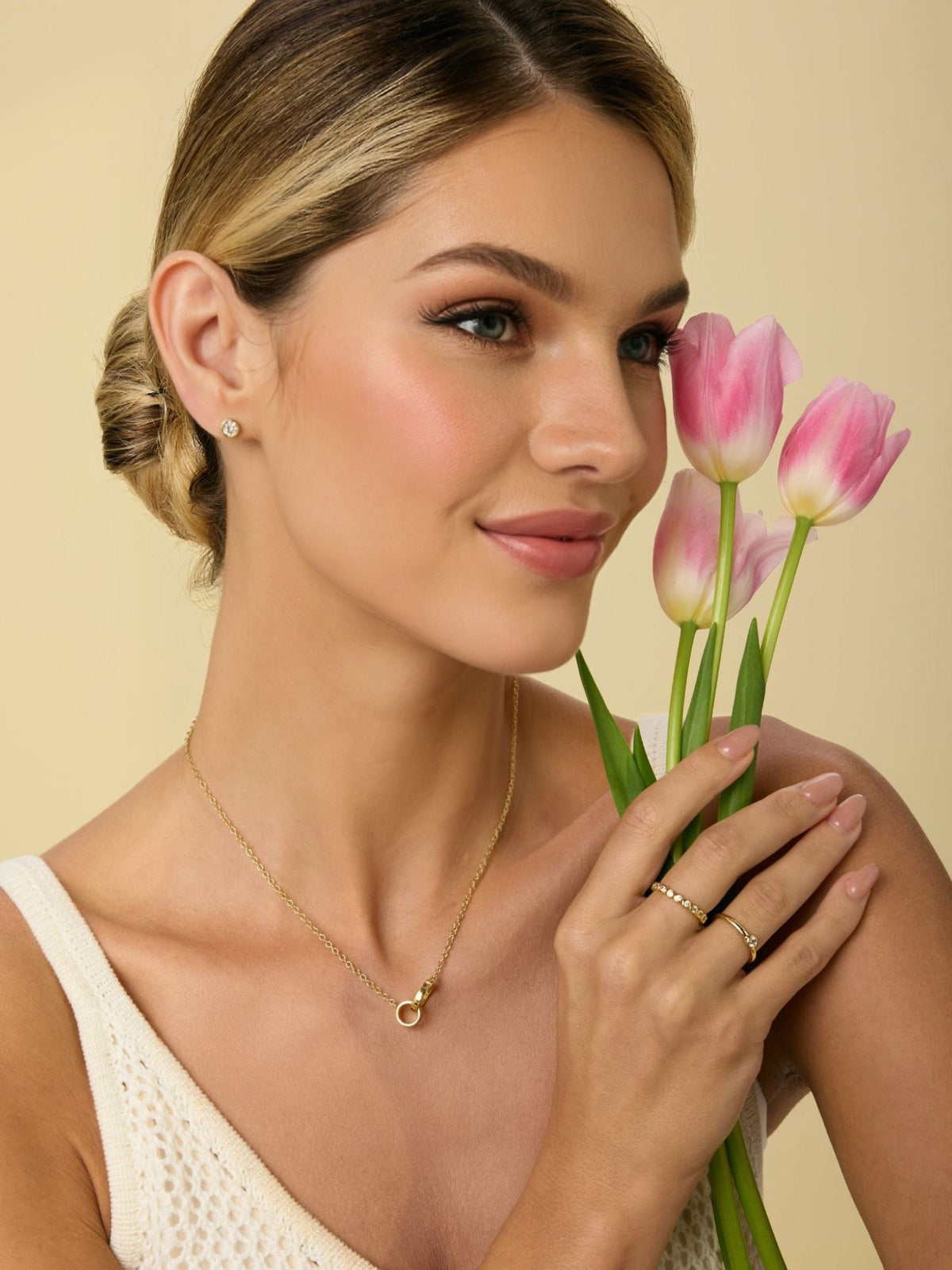 Gold round diamond stud earrings with bezel setting, worn on ear