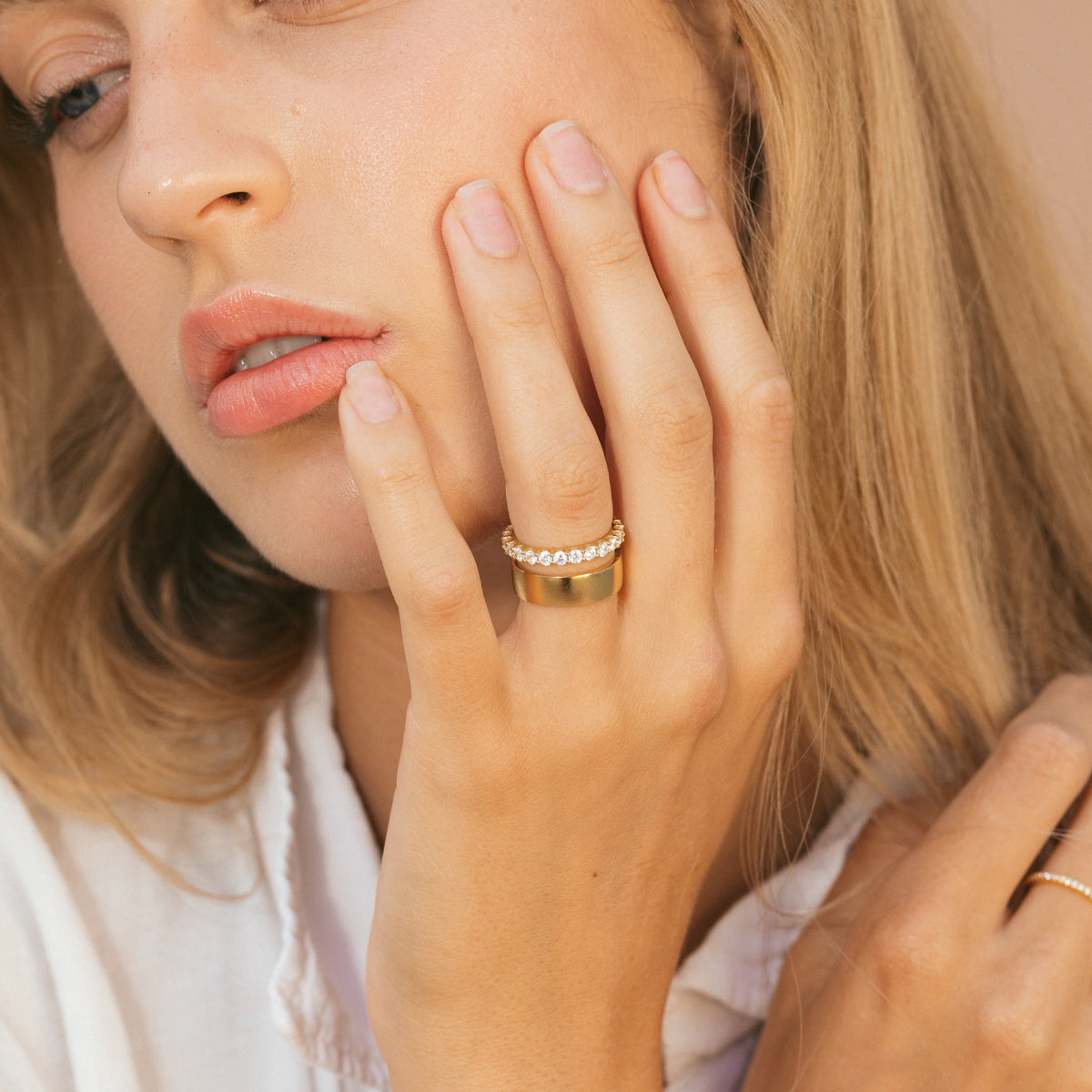 Gold eternity ring with clear stone row on finger