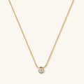 Gold chain necklace with round bezel-set diamond pendant