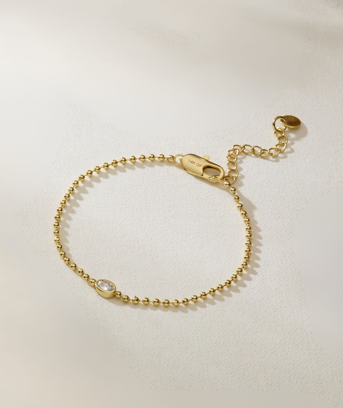 Gold oval bracelet with toggle clasp and oval diamond detail at center