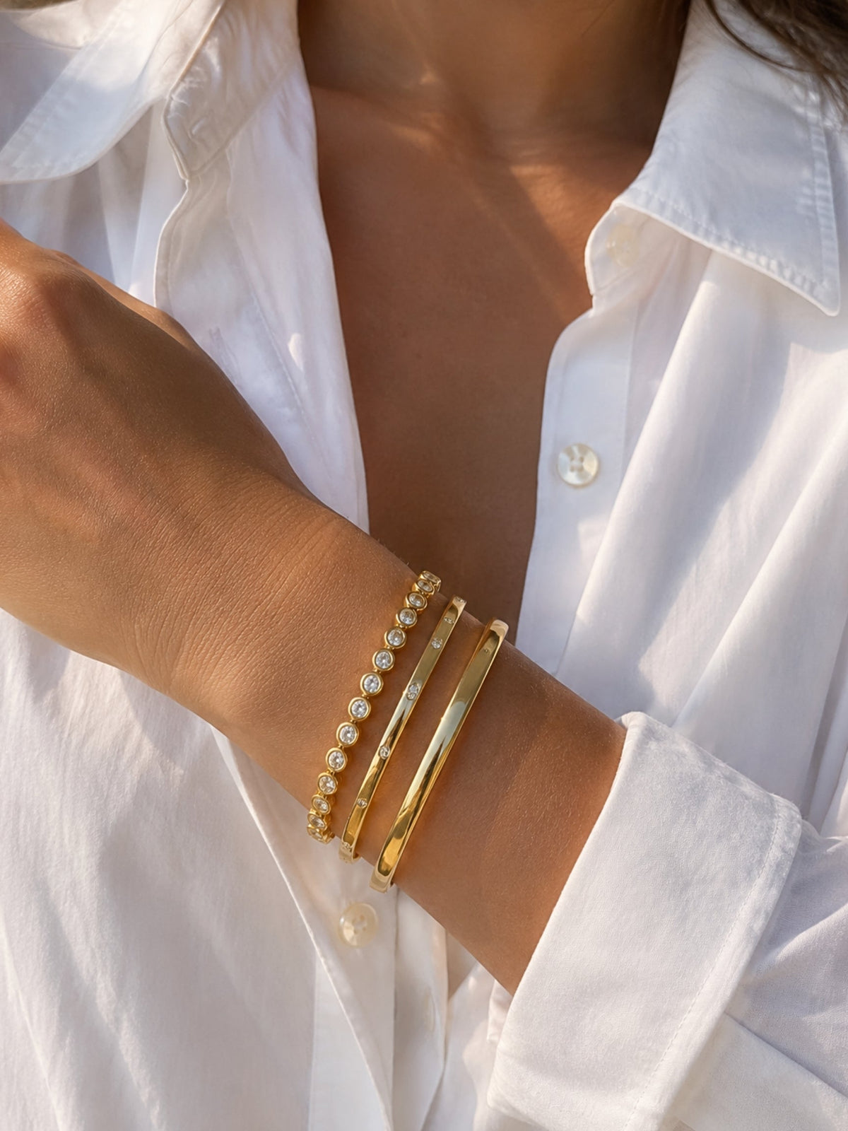 Gold-tone cuff bracelet with beaded accents and layered metal bands.
