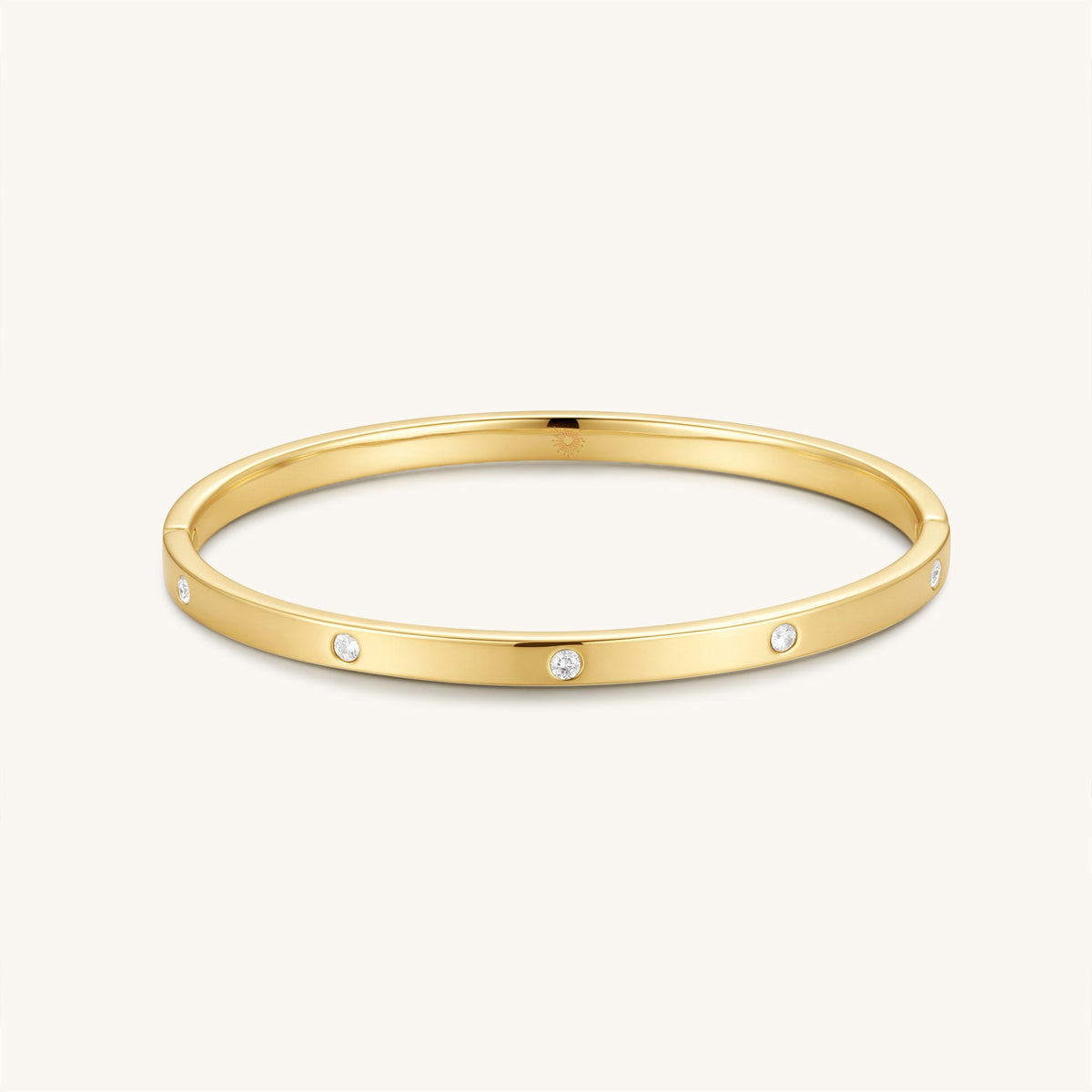 Gold-tone hinged bangle with small round diamond accents, open oval silhouette