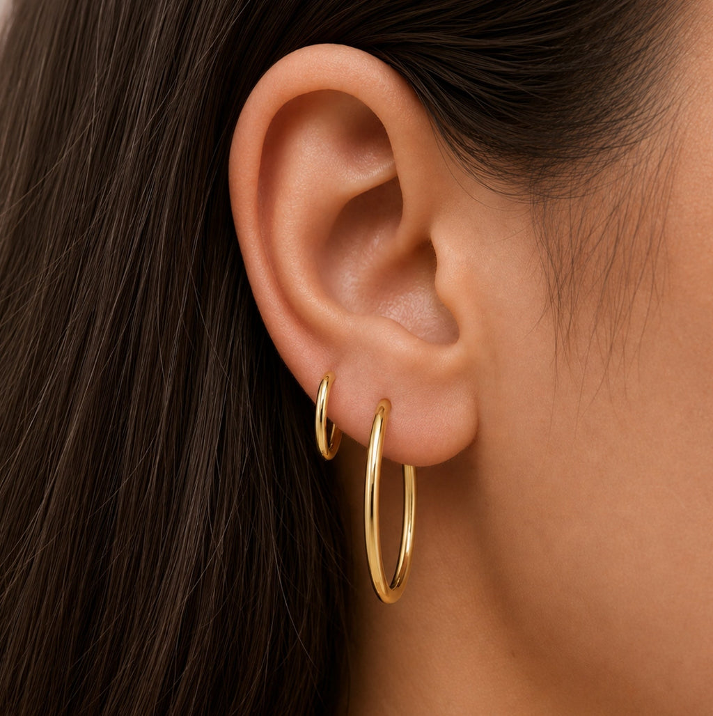 Gold hoop earrings on ear, small seamless round hoops
