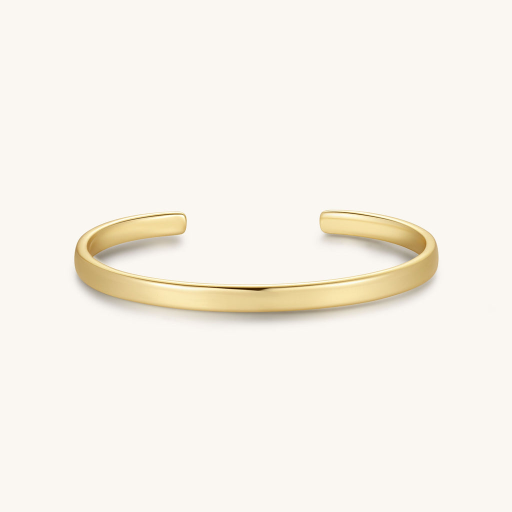 Gold-tone cuff bracelet with a smooth, flat band and open sides.