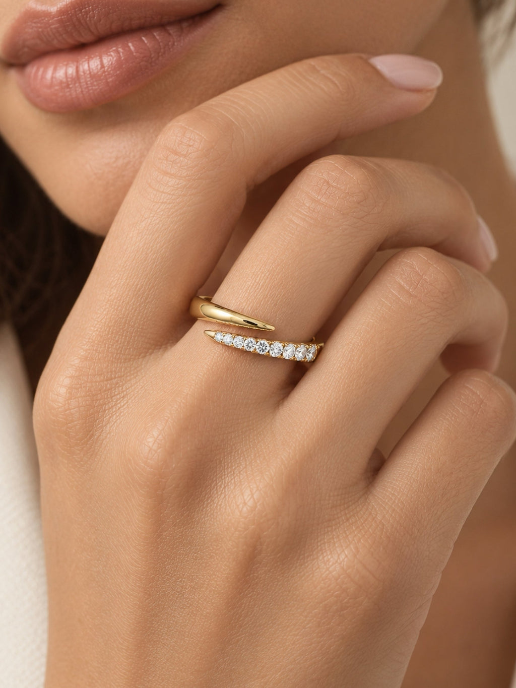 Gold filled pave spiral ring with curved band and clear stones on a hand