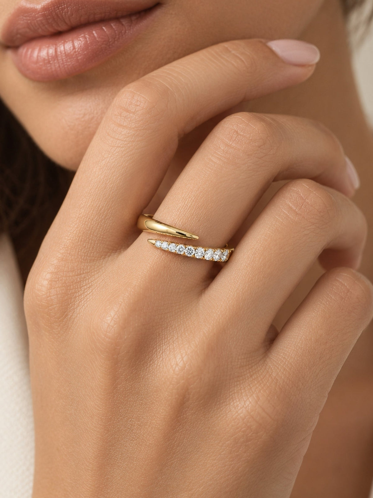 Gold filled pave spiral ring with curved band and clear stones on a hand