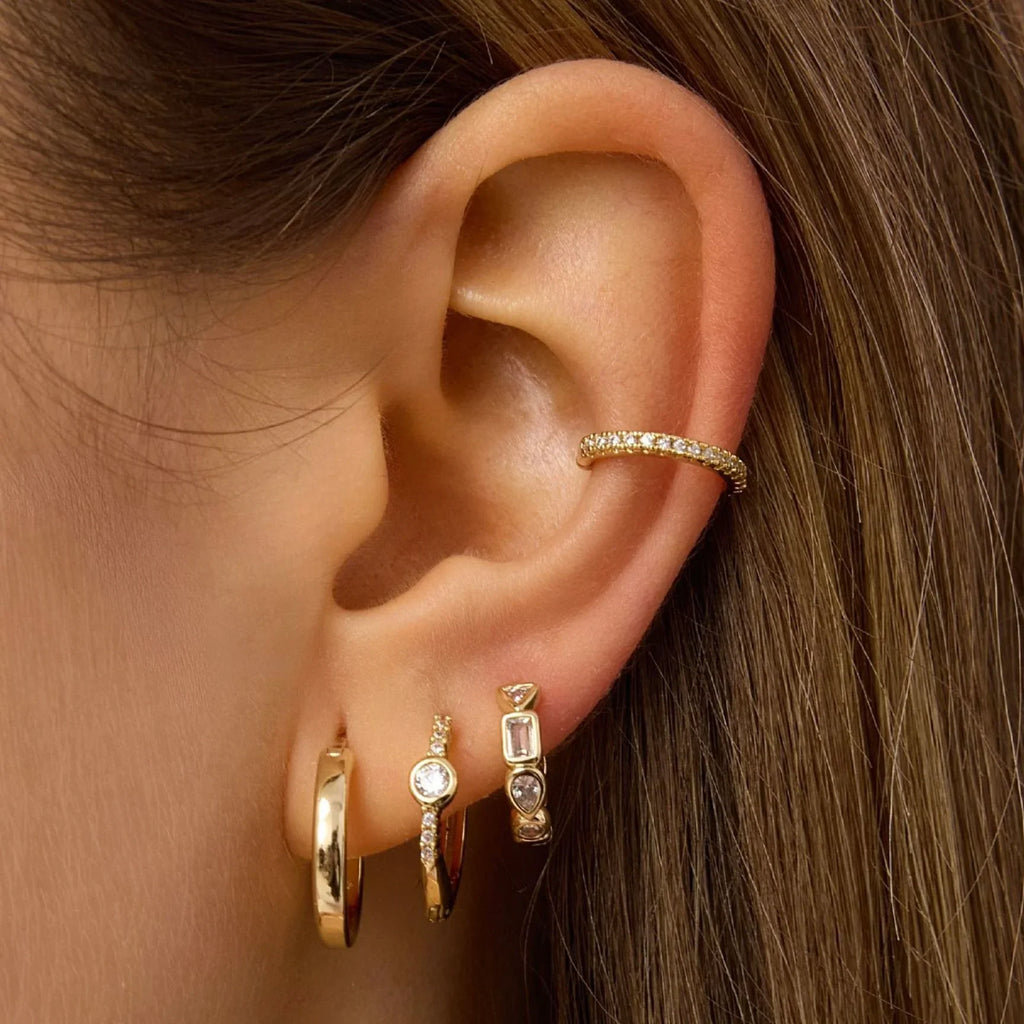 Gold hoop earrings with bezel-set stones, worn on ear