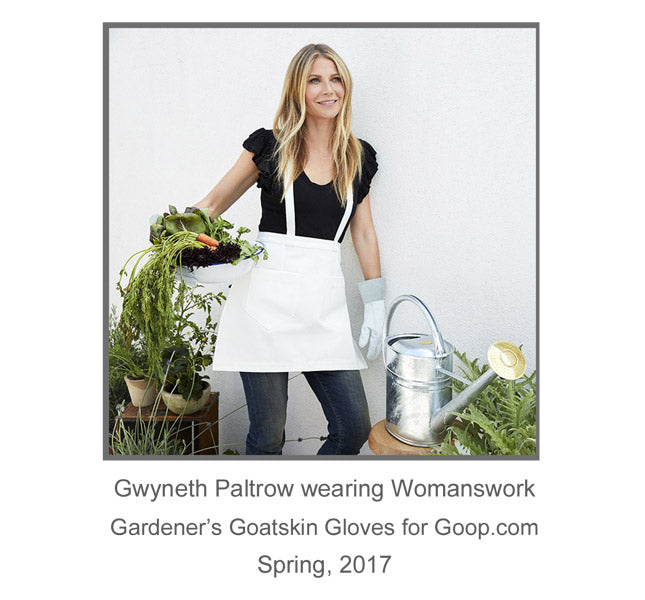 Light blue garden gloves on hands holding greenery, with suede cuff detail.