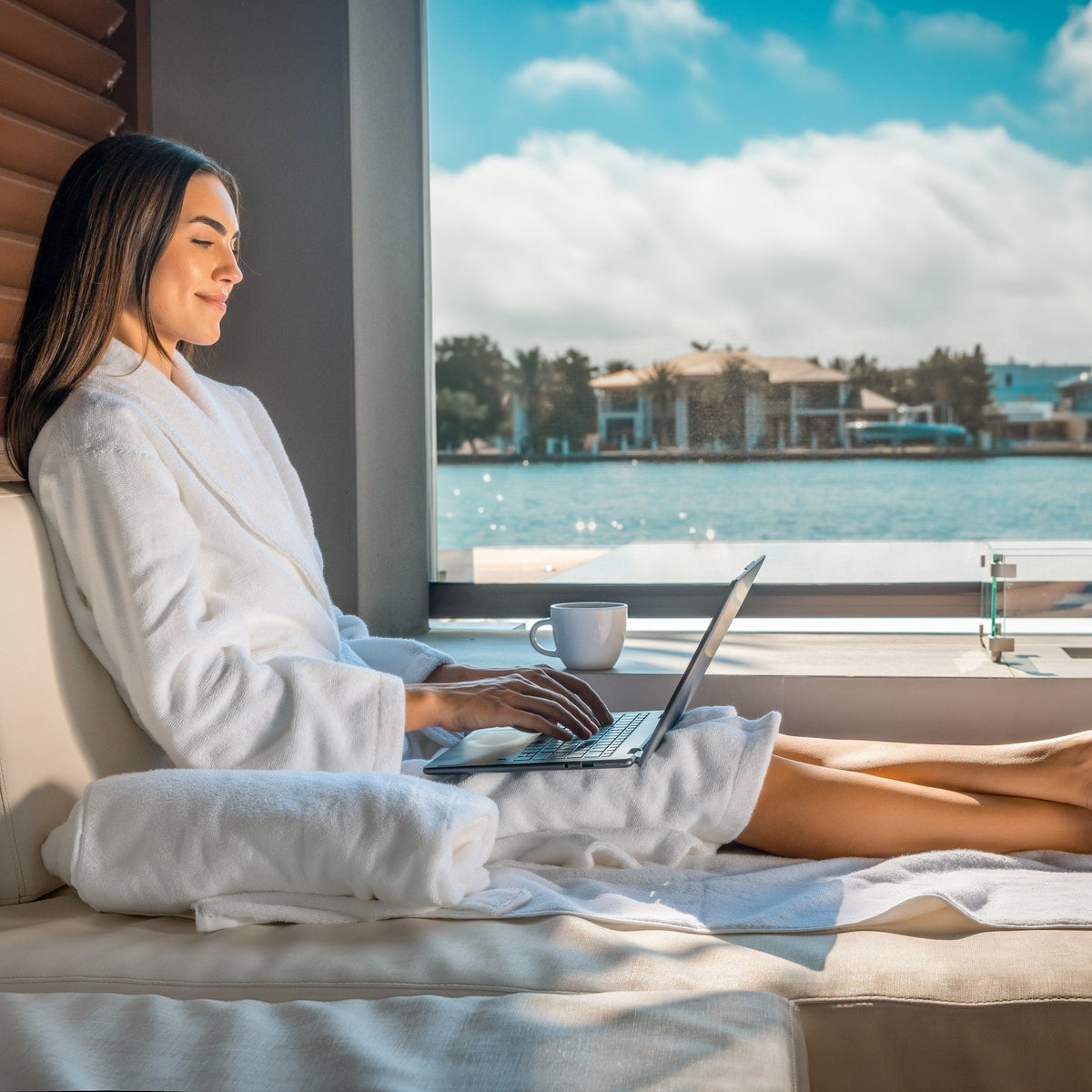 Light blue terry bathrobe with belt tie, worn while seated by window