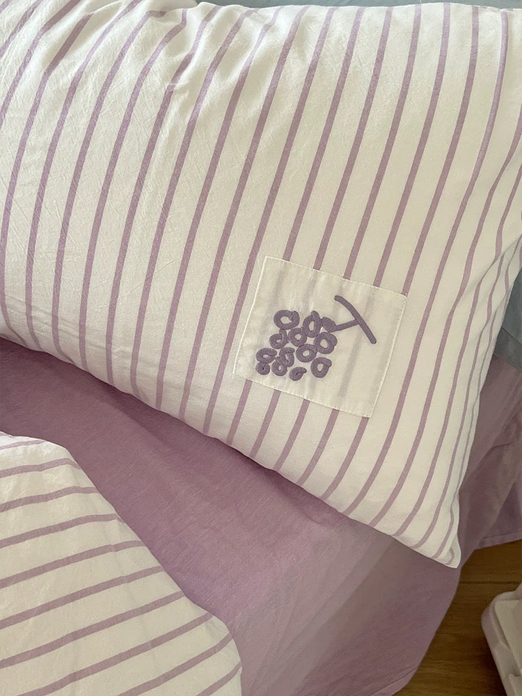 Close-up of striped pillow cover with purple flower applique