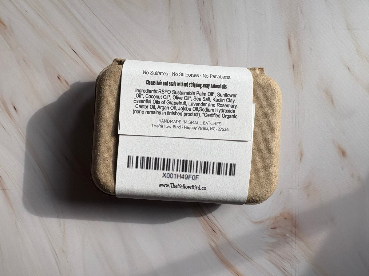 Shampoo bar with back label, barcode, and The Yellow Bird kraft wrapping