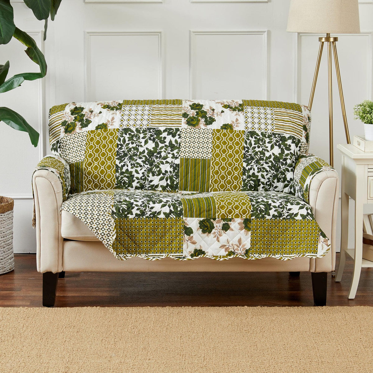 Reversible sofa protector with green and yellow patchwork quilt, floral and geometric prints