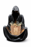 Grim reaper wax and oil warmer, dark hooded figure holding a glowing amber cup
