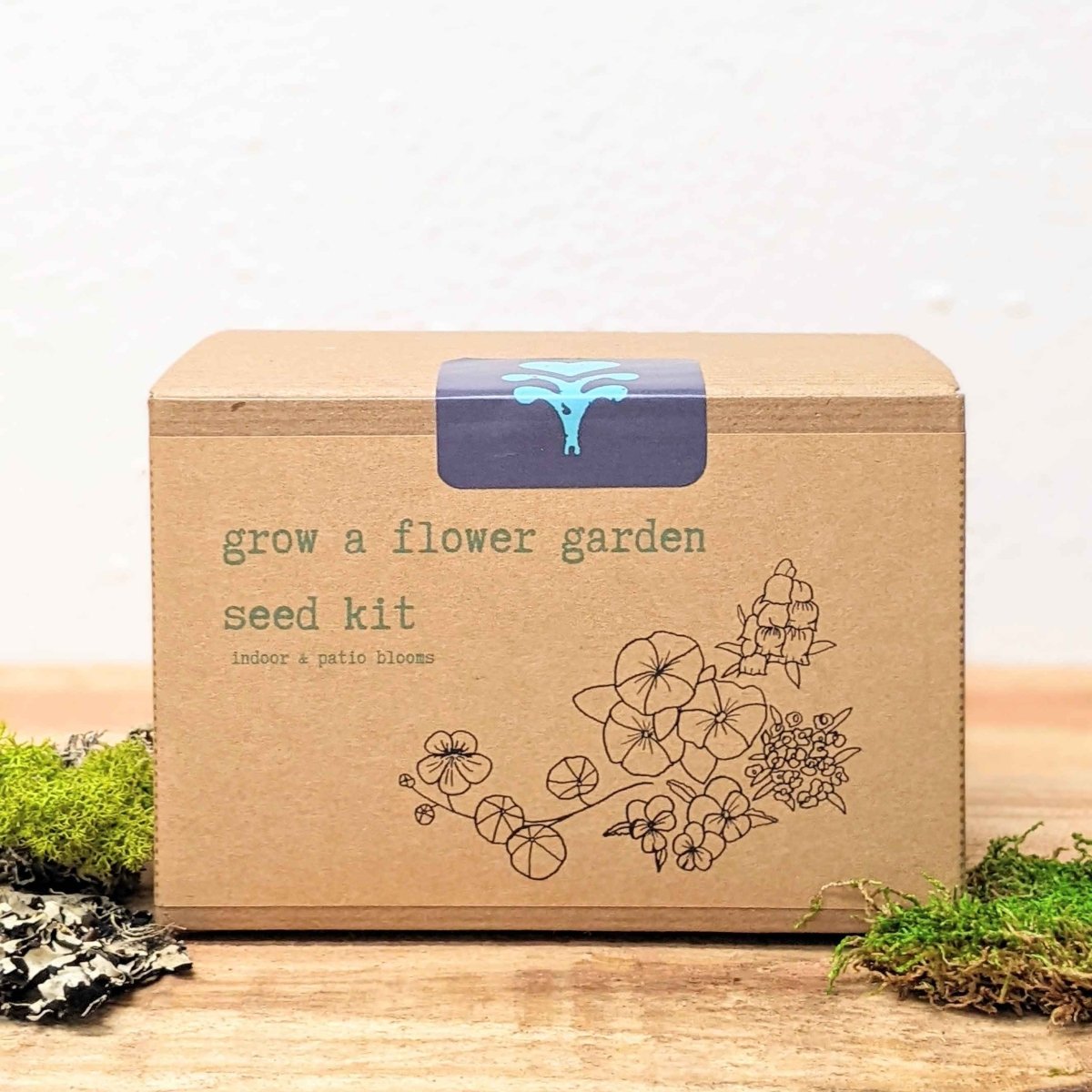 Kraft seed kit box front with blue logo panel and floral line illustration