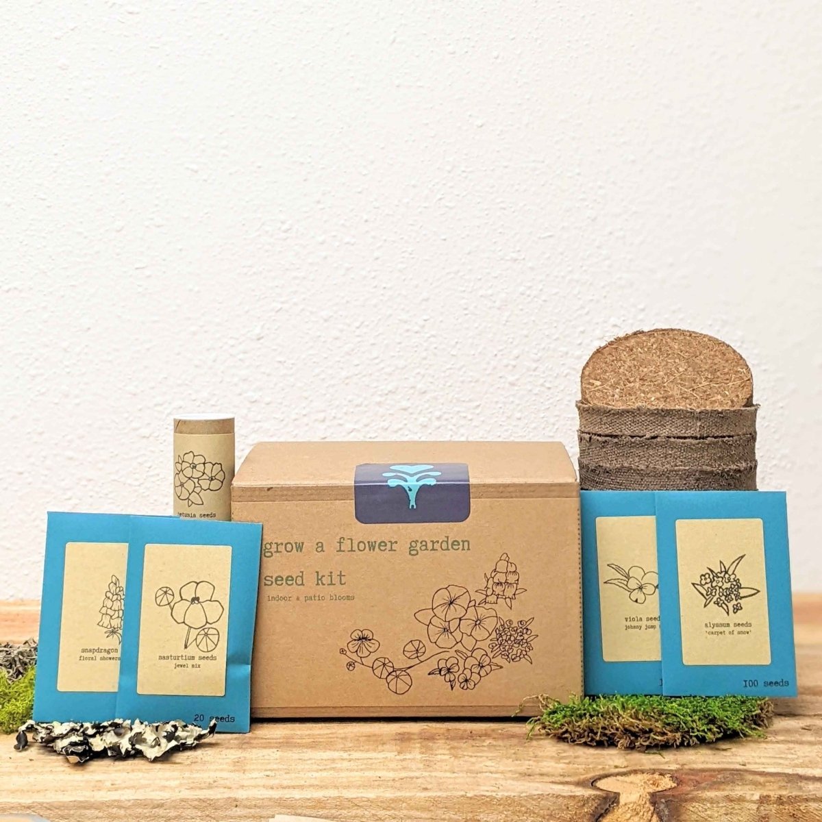 Flower seed kit box with small seed packs, coir pots, and moss base