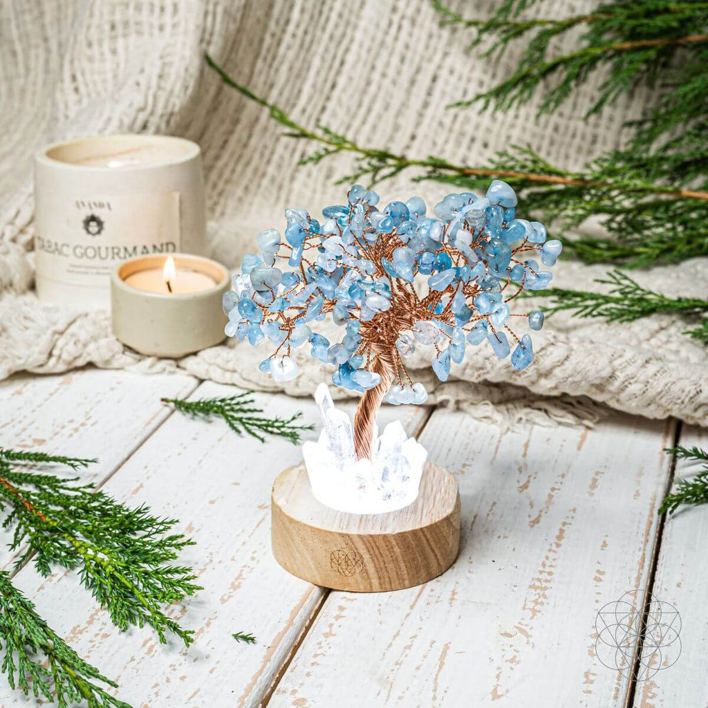 Aquamarine crystal tree lamp with blue branch clusters on a round wood base