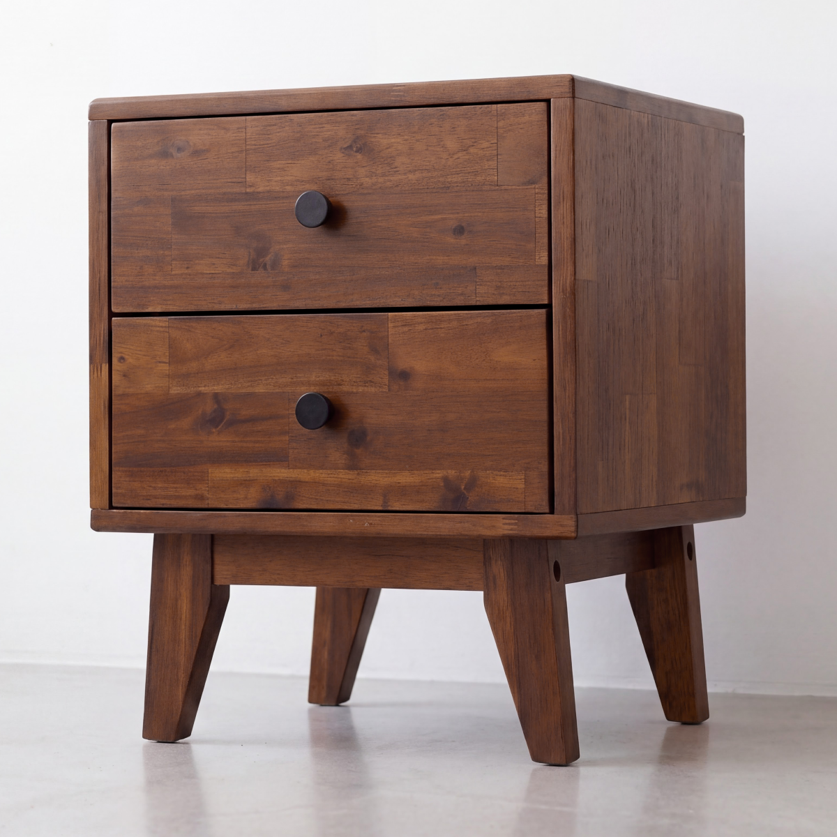 Solid wood nightstand side view with two drawers and round knobs on tapered legs.