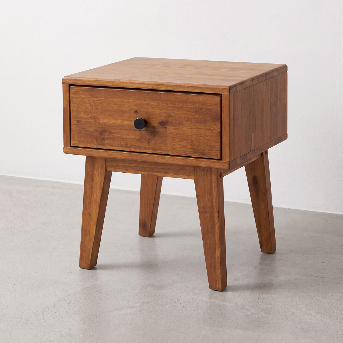 Medium brown solid wood nightstand with one drawer and black round knob