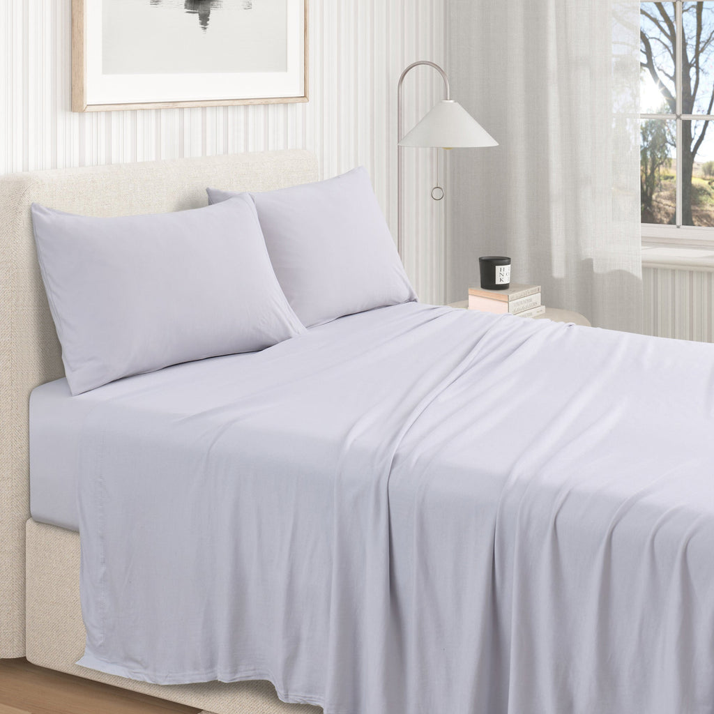 Jersey knit sheet set on bed with pillows, light grey