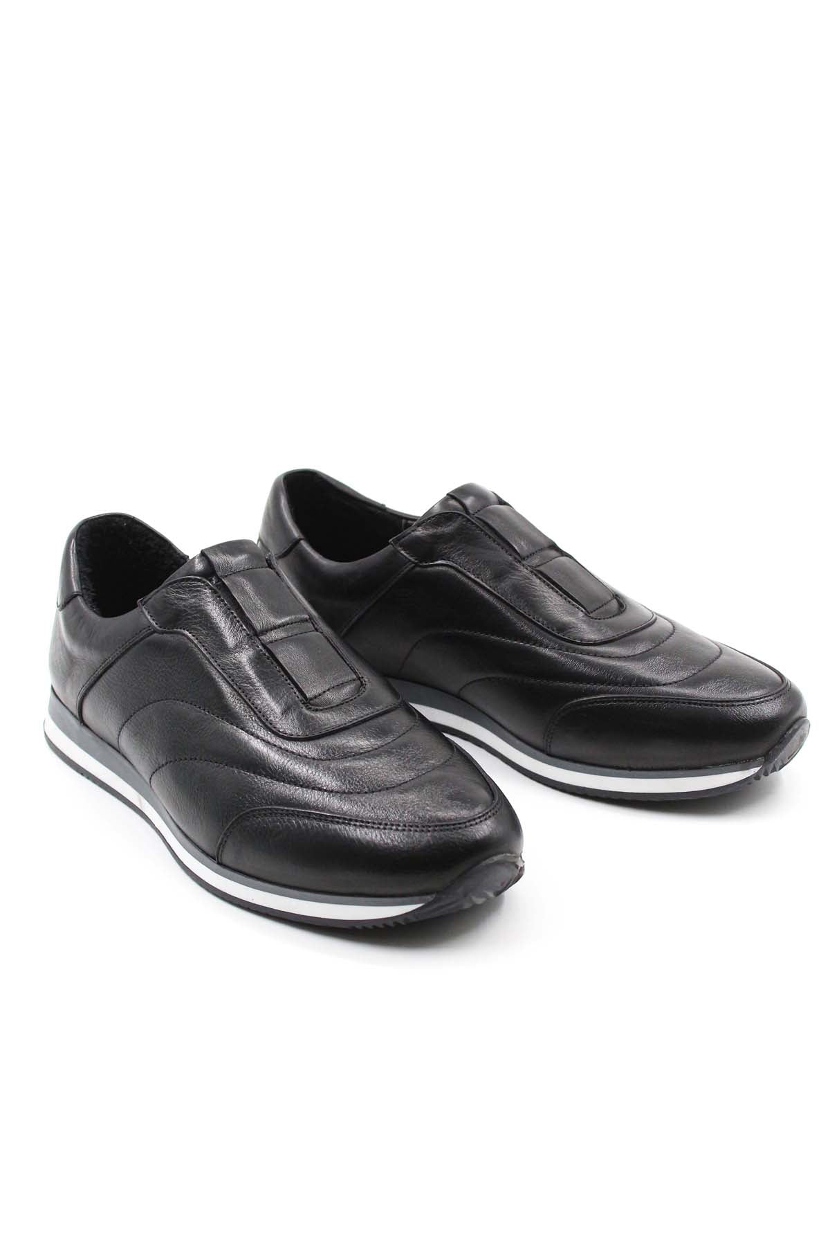 Pair of black leather low-top sneakers with contrast white soles, angled view.