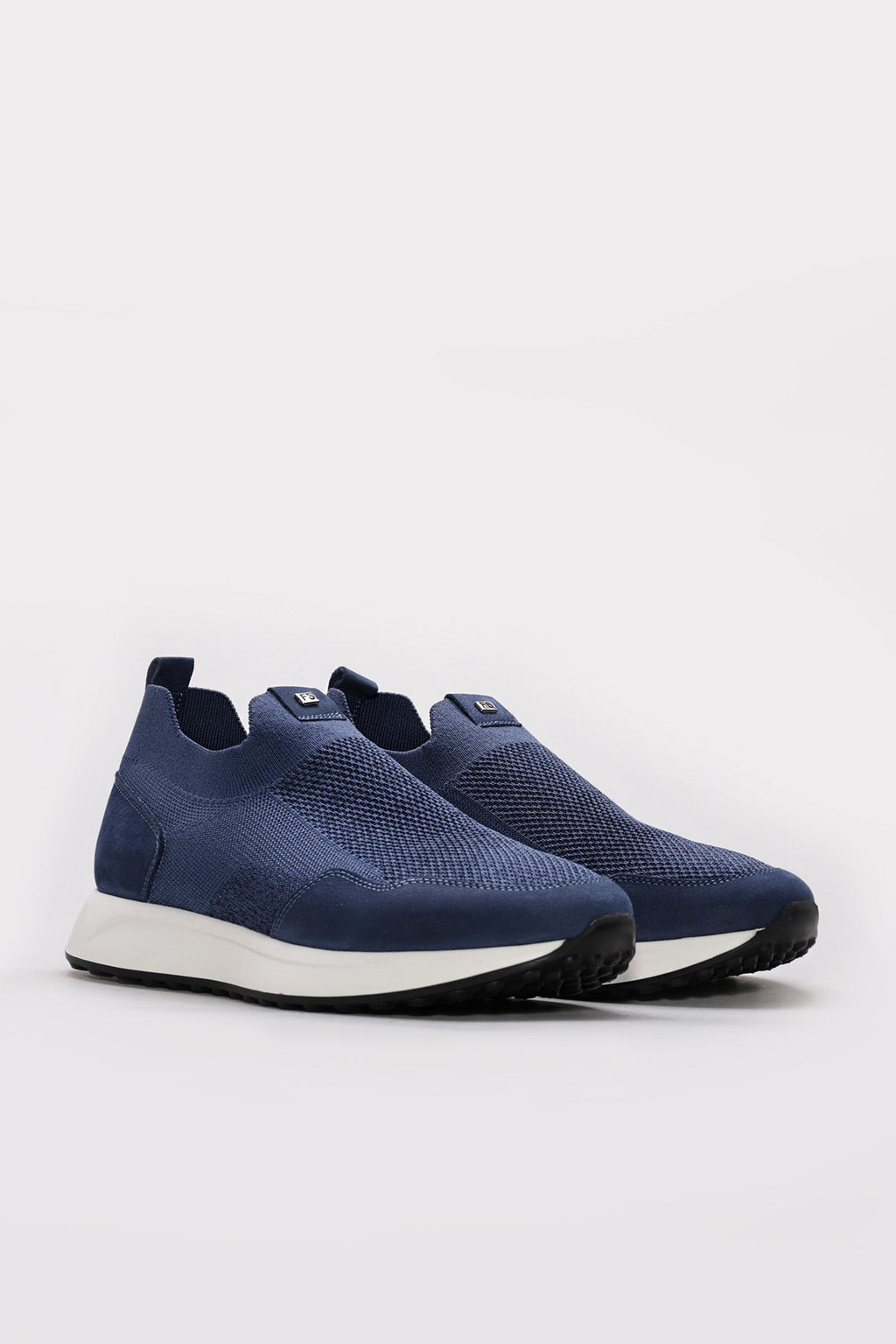 Pair of blue textured slip-on sneakers with white midsoles and dark tread