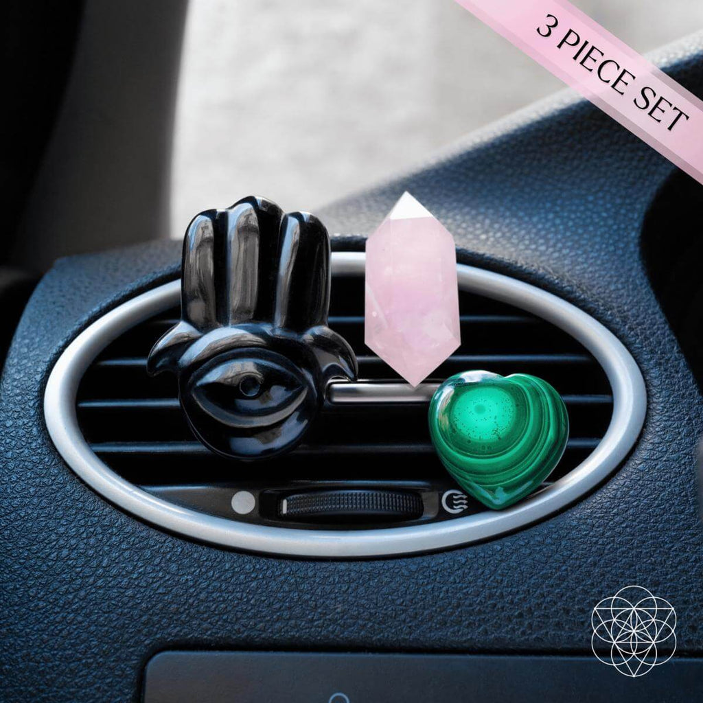Black hamsa car diffuser with pink rose quartz and green heart crystal on dashboard vent