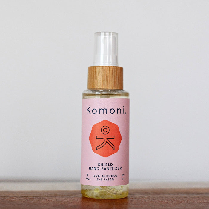 Instant hand sanitizer bottle in pink with clear spray cap and wood collar