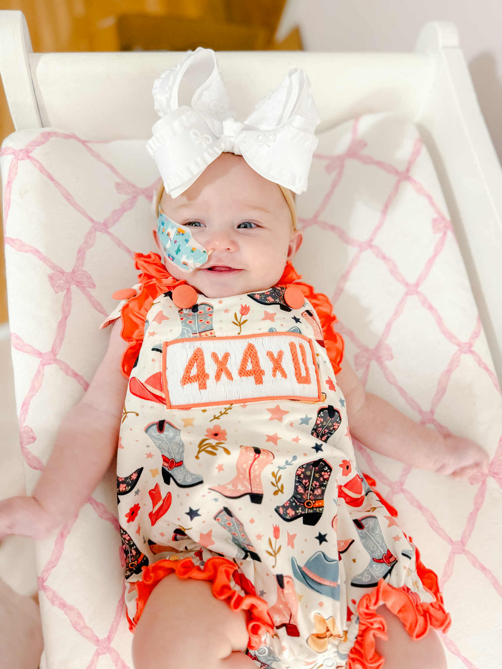 Girls smocked 4X4U sunsuit on doll, coral bow straps, star/rocket print