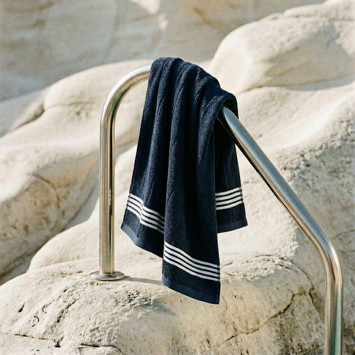 Cotton towel draped on rack, navy with white striped bands