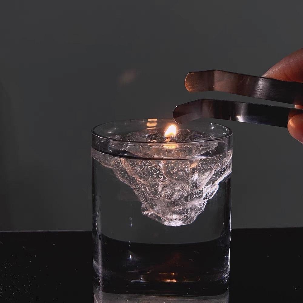 Transparent iceberg-shaped jelly wax candle with lit wick, frosty gray translucent wax
