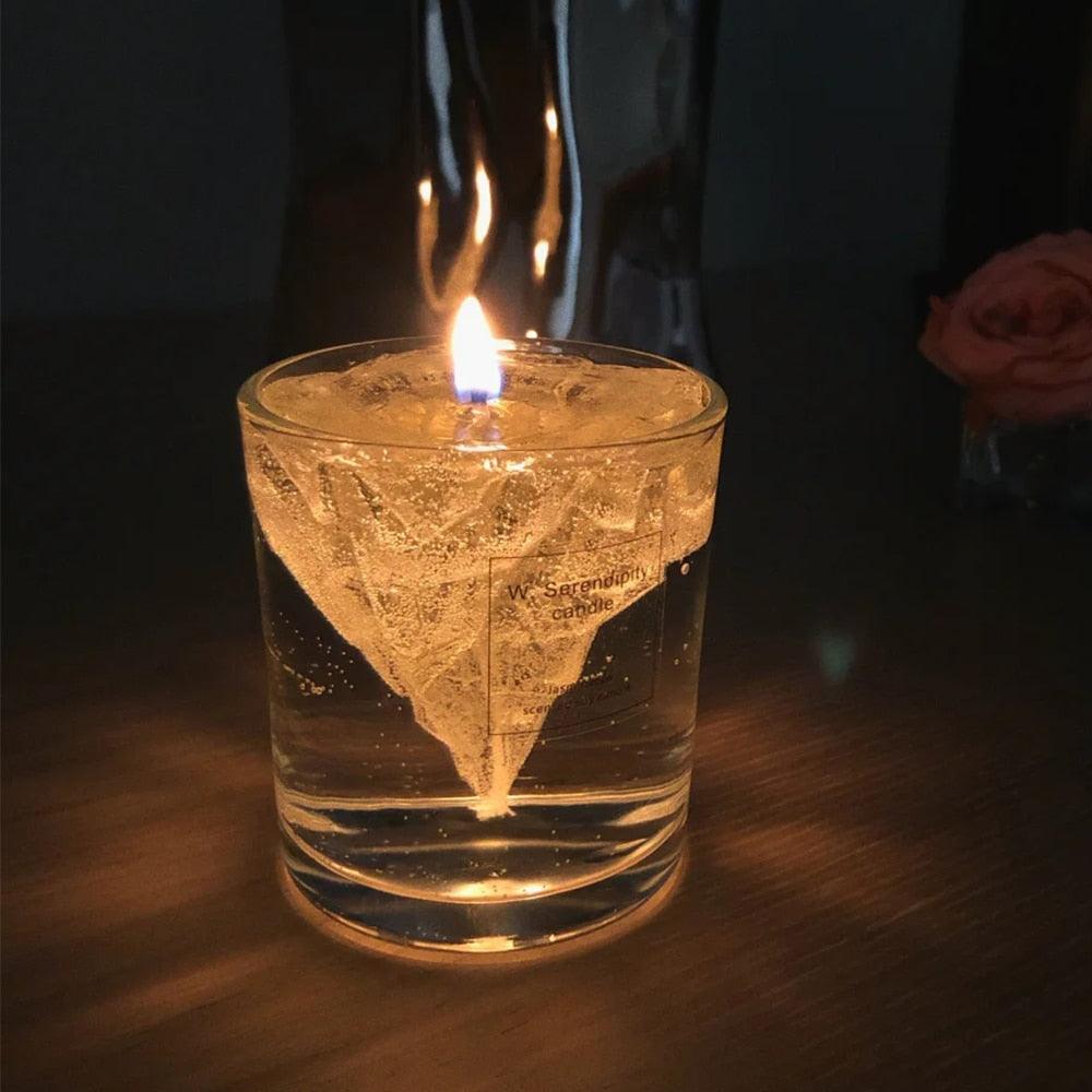 Clear iceberg-shaped jelly wax candle with lit wick, gray-toned translucent wax