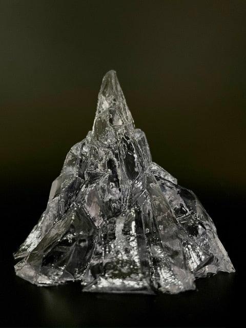 Transparent iceberg-shaped candle with unlit wick, cool gray crystal-like wax