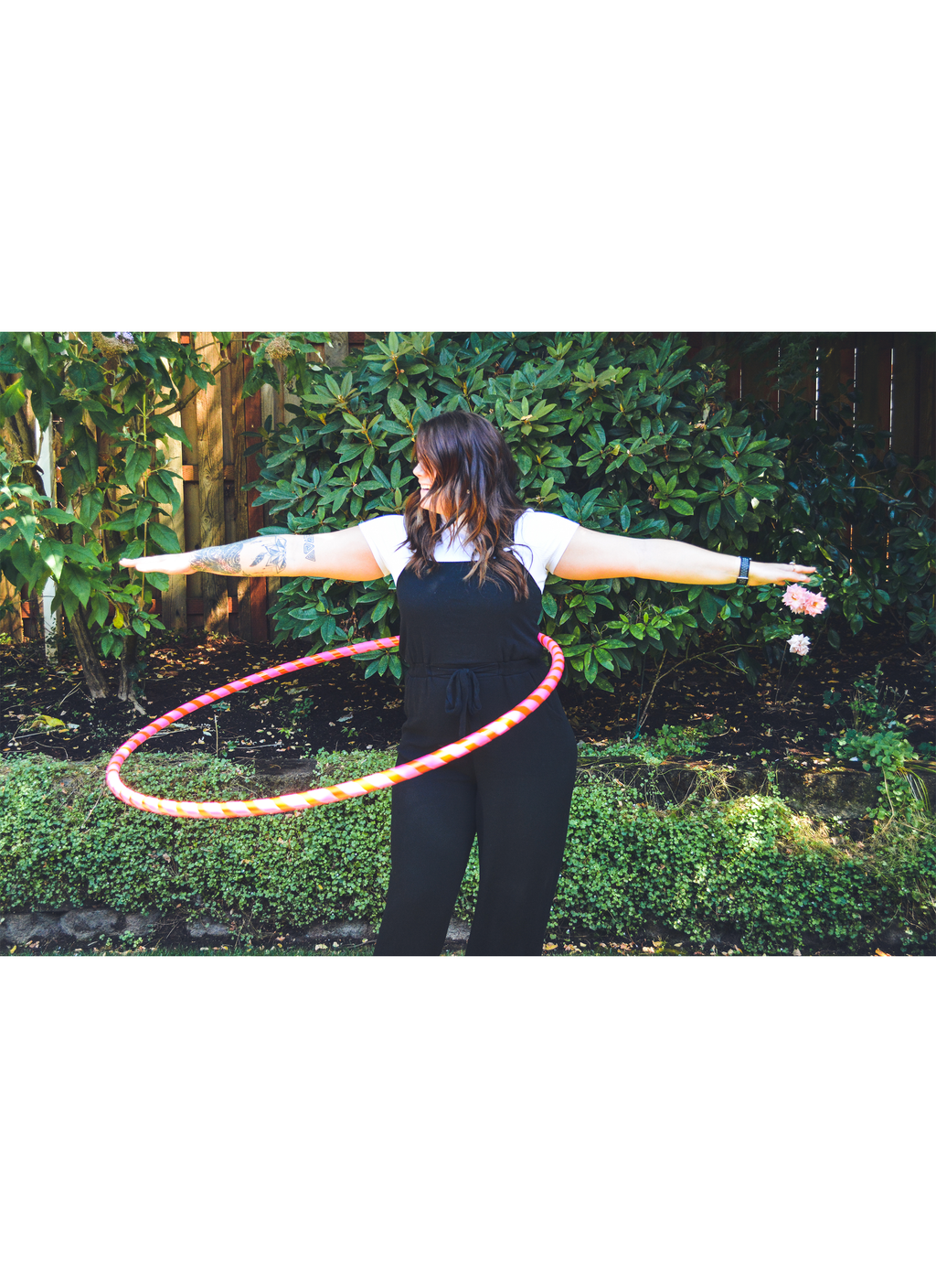 Prism-taped beginner weighted hula hoop held by a person outdoors