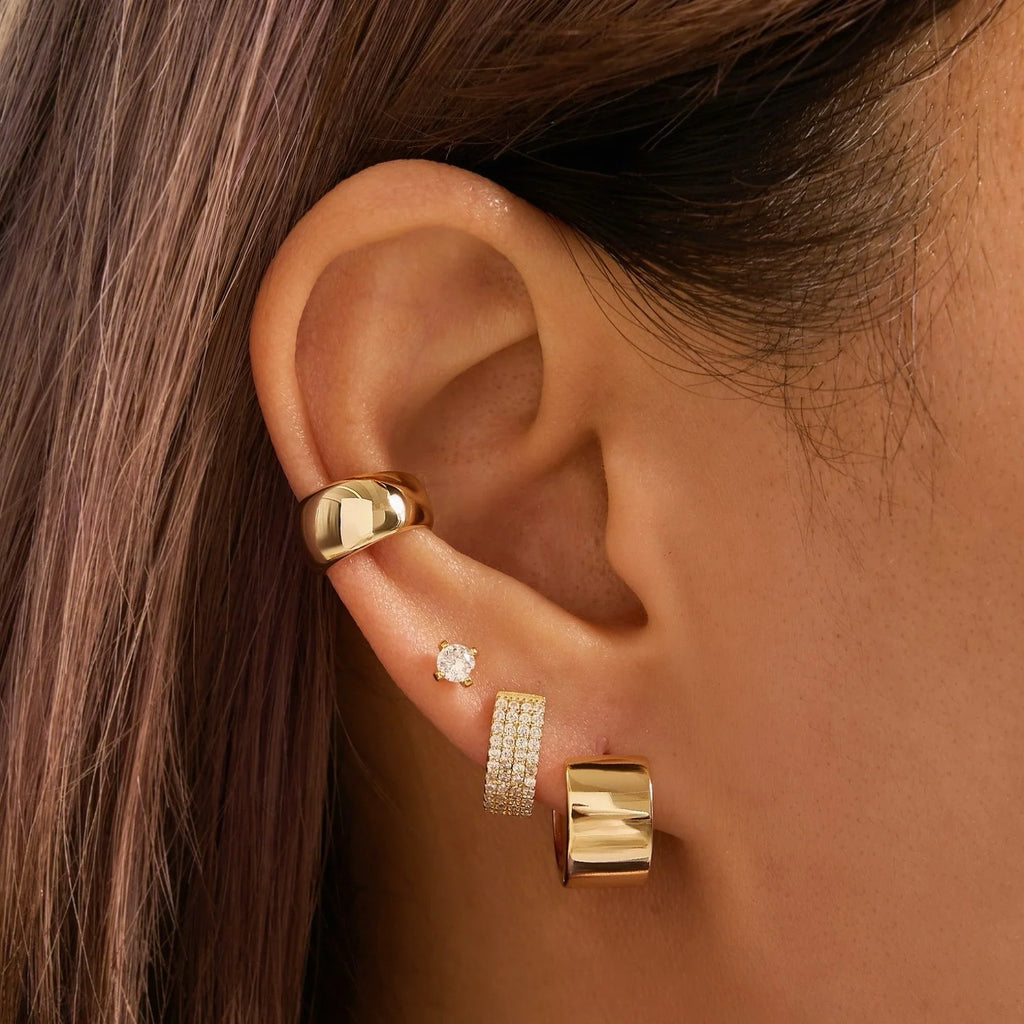 Gold hoop earring set on ear with crystal stud, pavé hoop, and chunky hoop