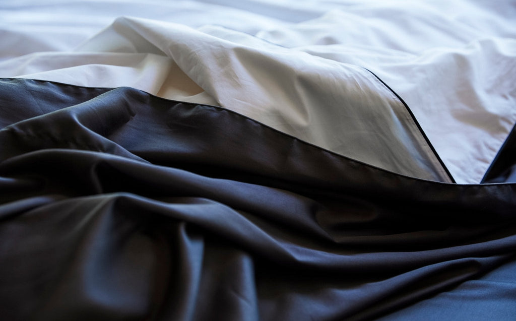 Silk-filled duvet set with white and dark layers, black piping along the edge
