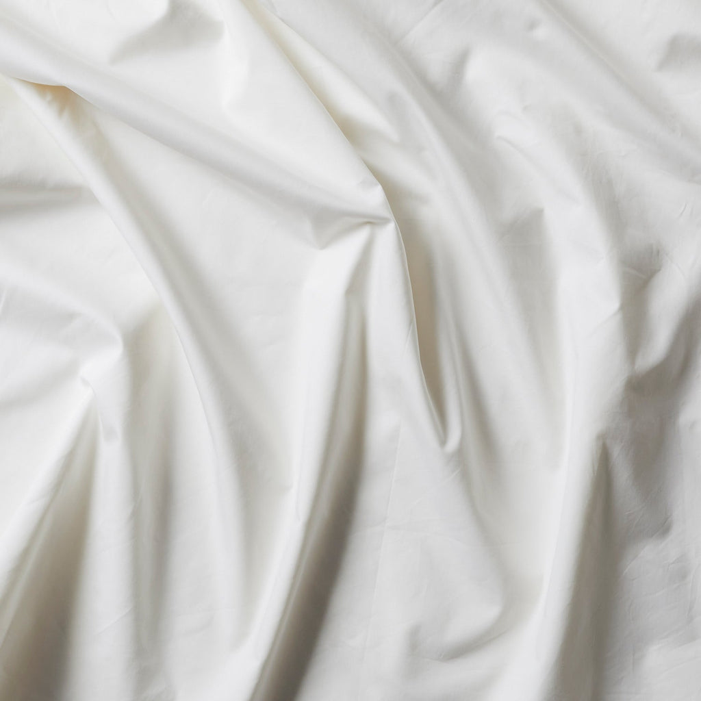 White silk-filled duvet with smooth fabric texture and subtle wrinkled creases