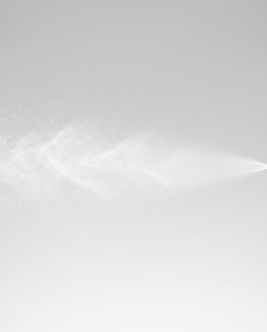 Mineral SPF 50 sheer spray creating a fine mist cloud